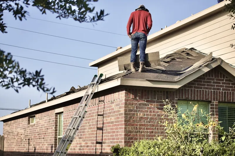 Professional roofer working on a residential roof in Bay Side